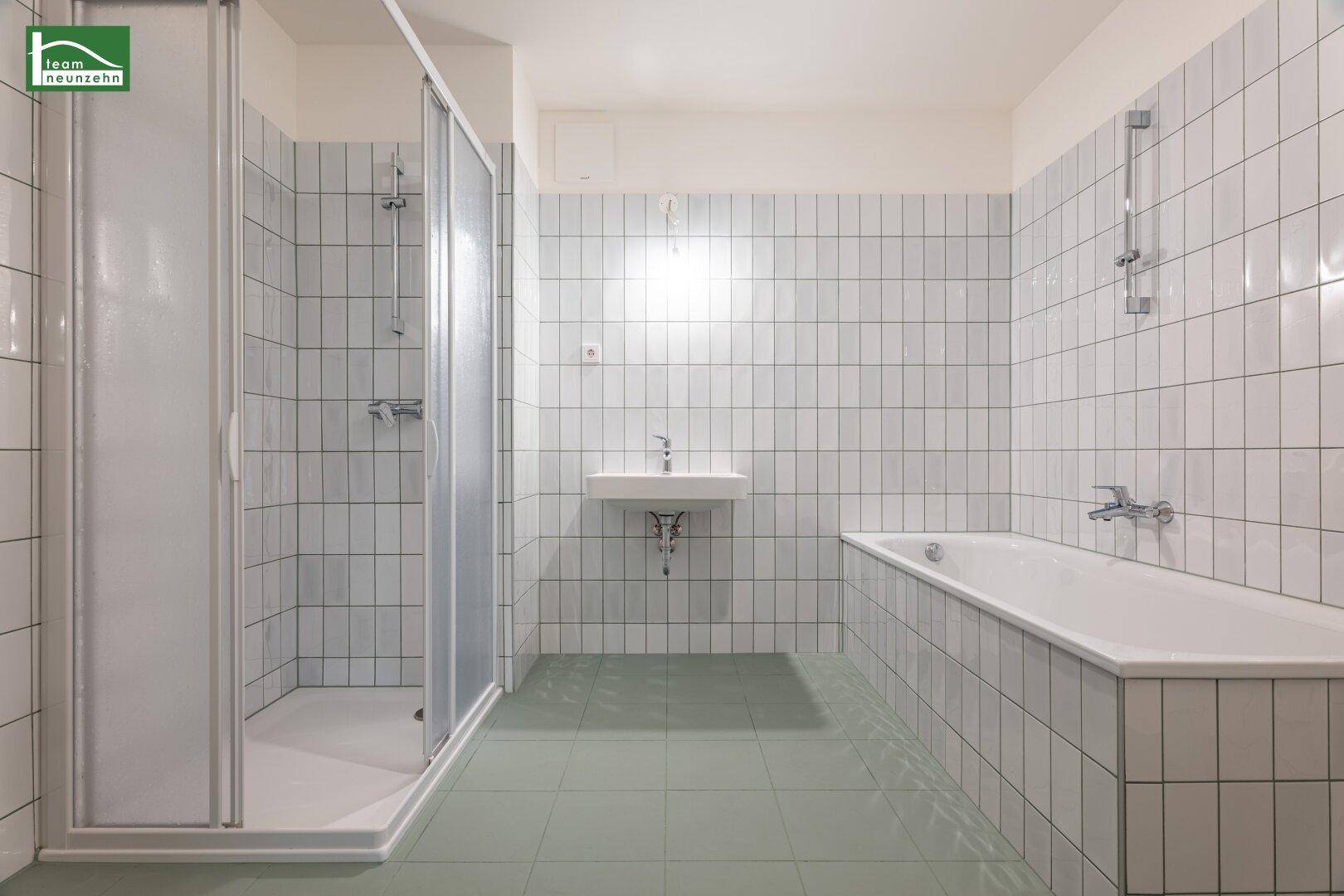 Funktionales Badezimmer mit Badewanne, separater Duschkabine und weiß gefliesten Wänden.