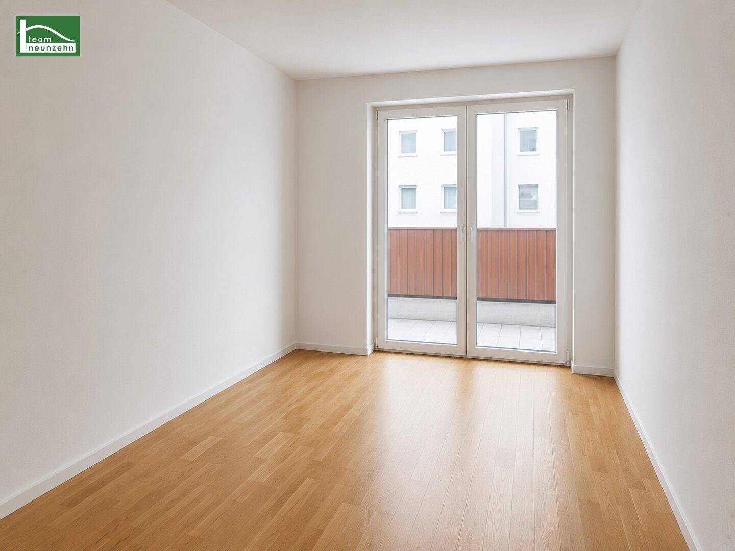 Leeres Schlafzimmer mit Parkettboden und großen Fenstern, die viel Tageslicht hereinlassen.