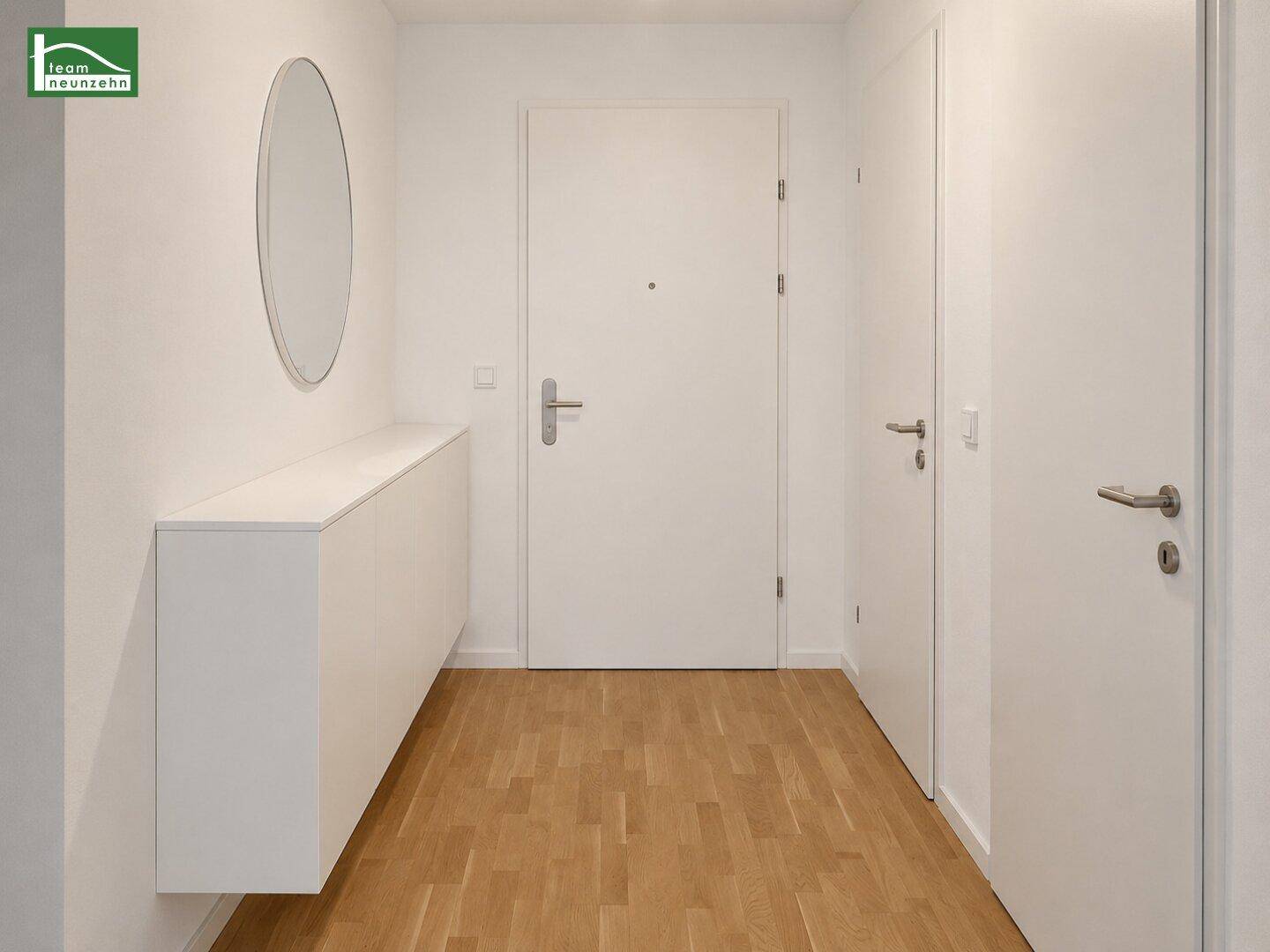 Eingangsbereich mit modernem Spiegel, schwebendem Sideboard und hellem Parkettboden.