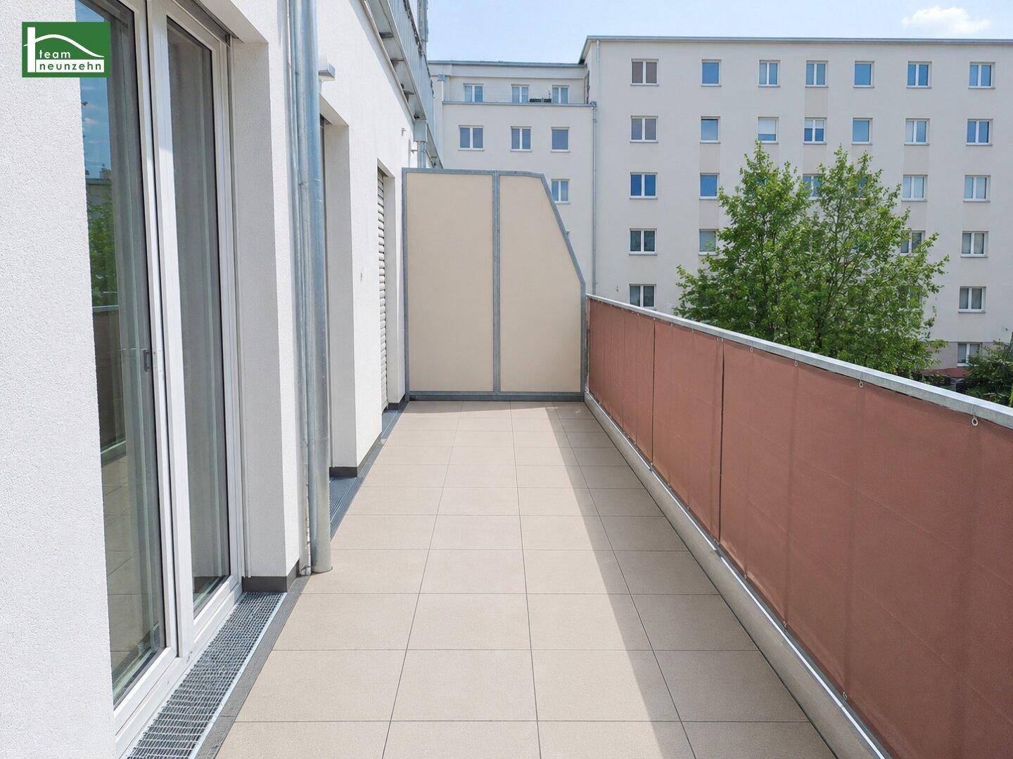 Langer, schmaler Balkon mit Fliesenboden und Sichtschutz, ideal für Entspannung im Freien.