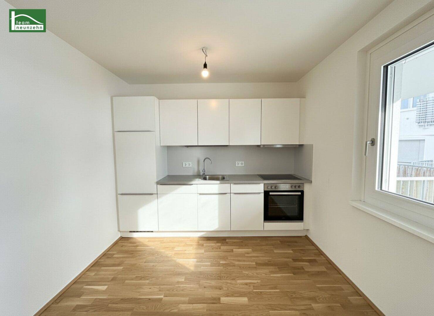 Moderne, kompakte Einbauküche mit weißen Schränken und integrierten Geräten.