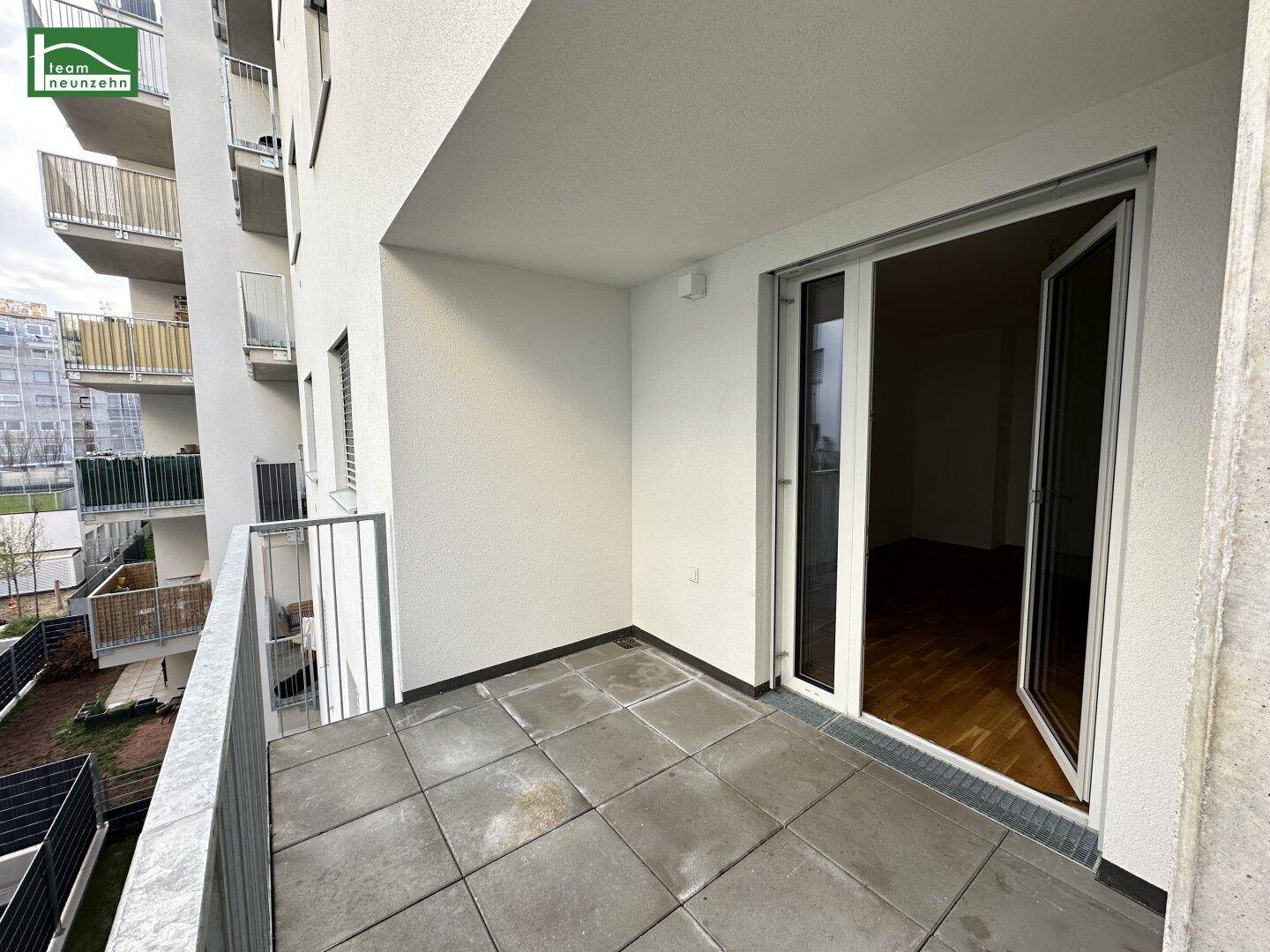 Heller Balkon mit Fliesenboden und Metallgeländer, zugänglich vom Wohnbereich.