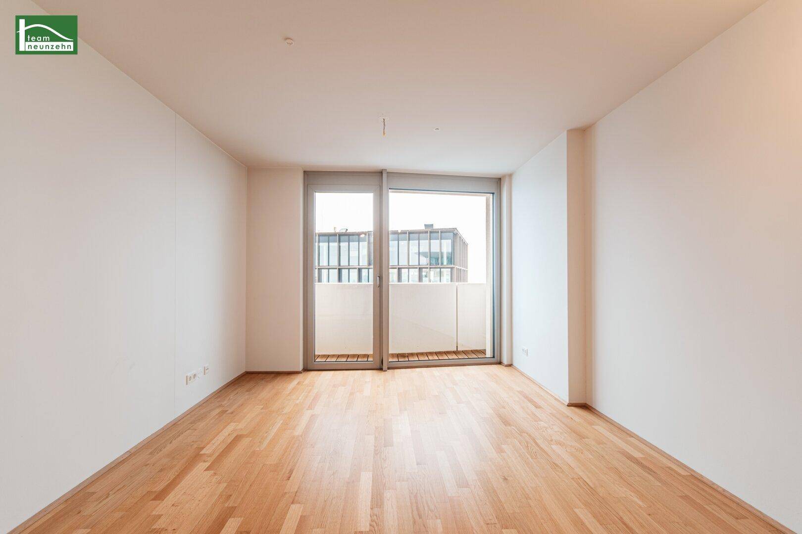 Heller Raum mit Holzboden und Zugang zu einem Balkon, ideal für individuelle Gestaltung.