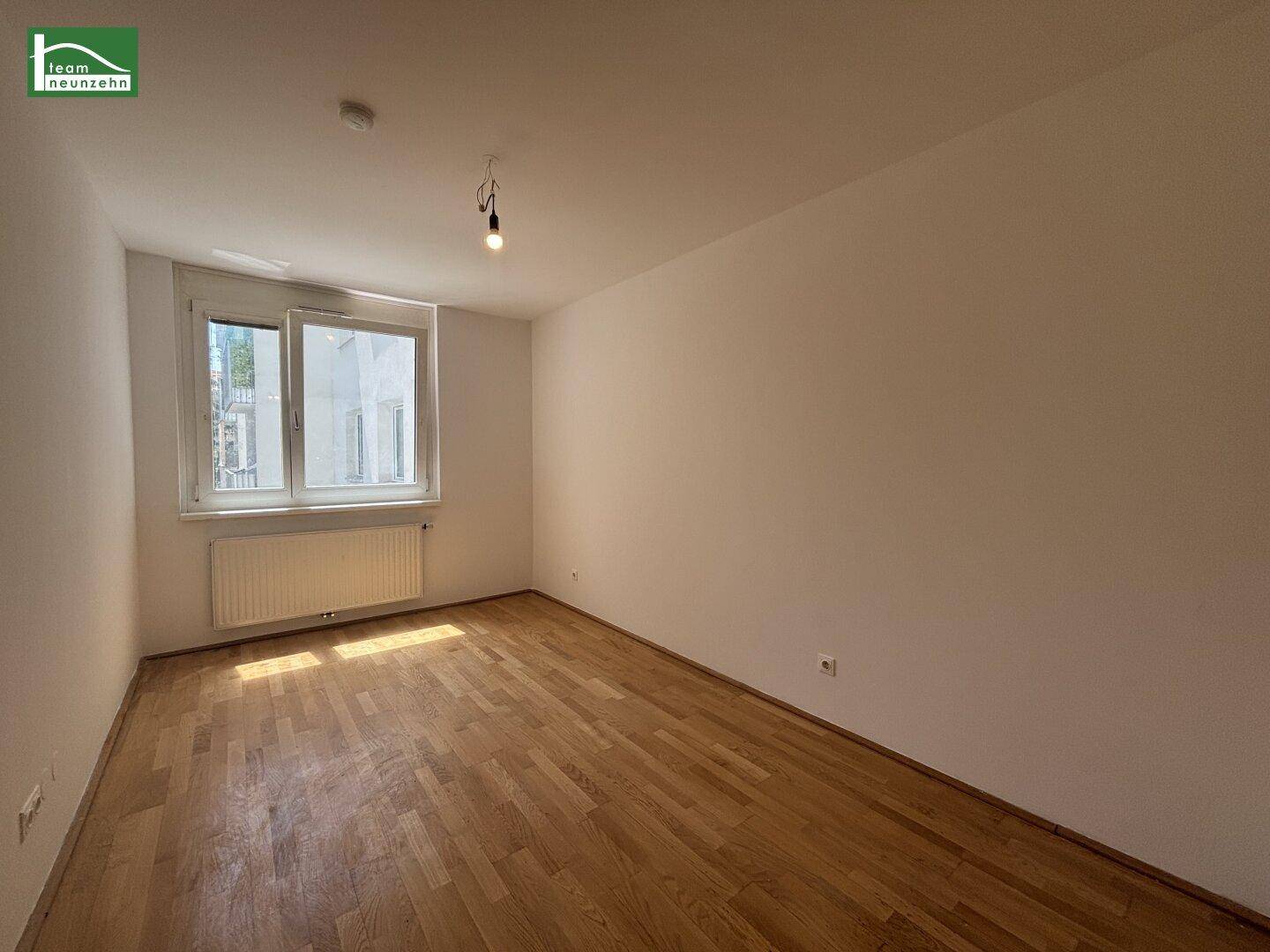 Helles, unmöbliertes Zimmer mit Parkettboden und Fenster, vielseitig nutzbar.