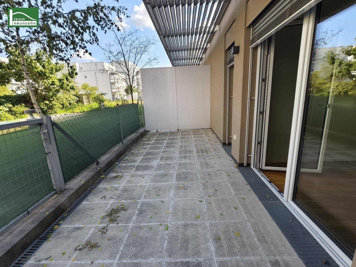 Geräumige Terrasse mit Steinplattenboden und Blick ins Grüne, ideal für entspannte Stunden im Freien.