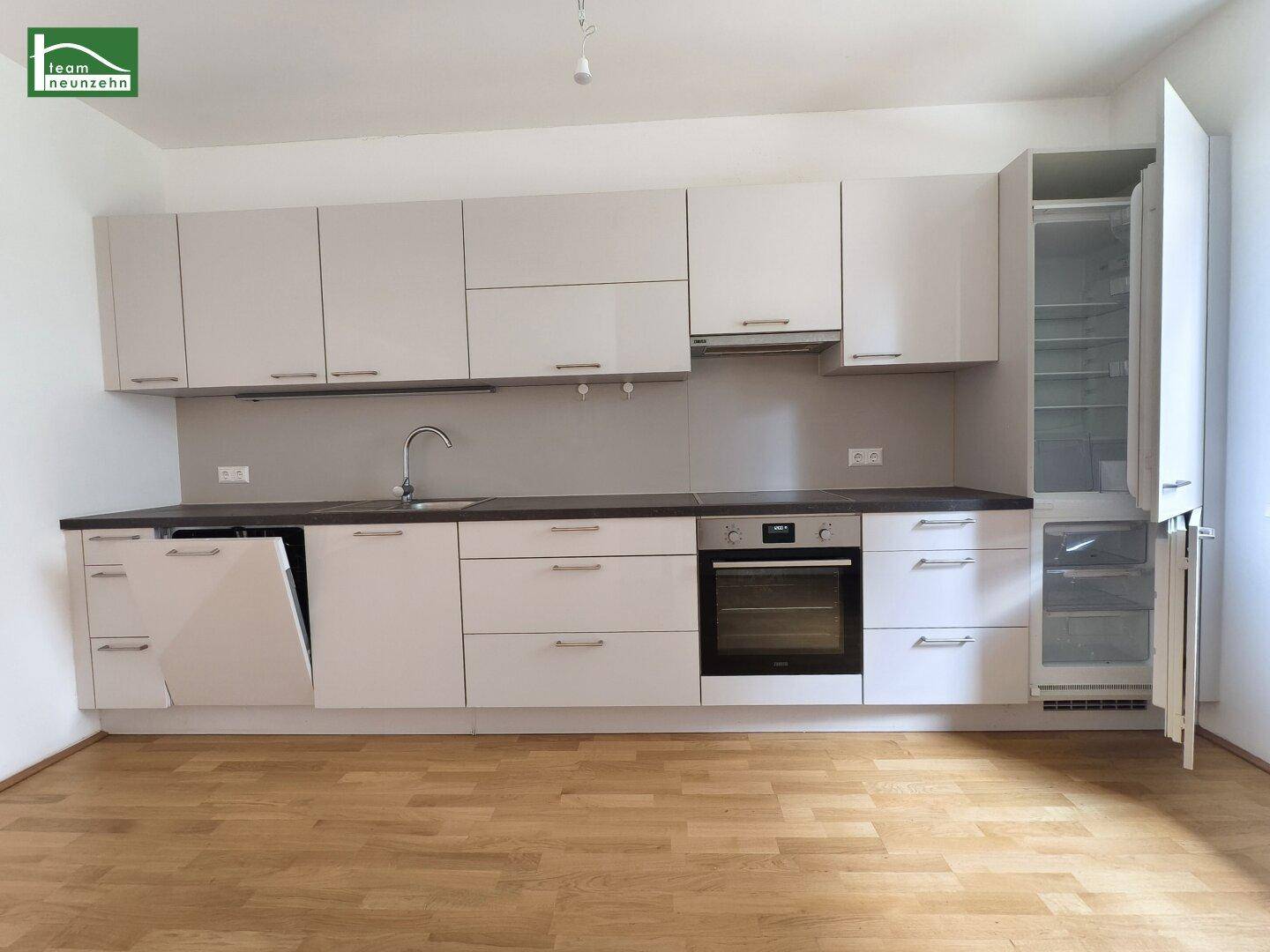 Detailansicht der modernen Einbauküche mit Spülmaschine, Backofen und Kühlschrank.