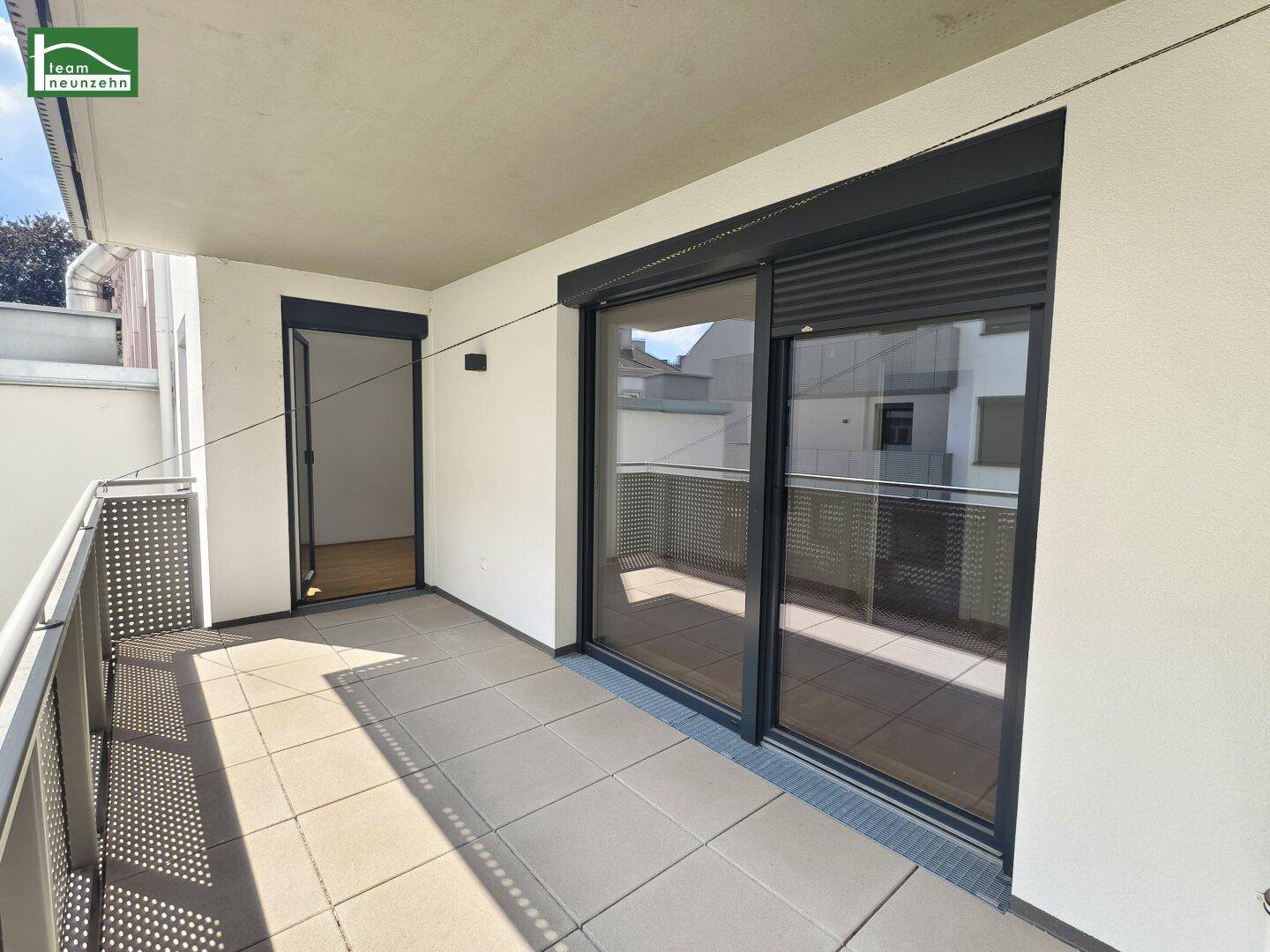 Geräumiger Balkon mit Fliesenboden und Metallgeländer, ideal für Entspannung im Freien.