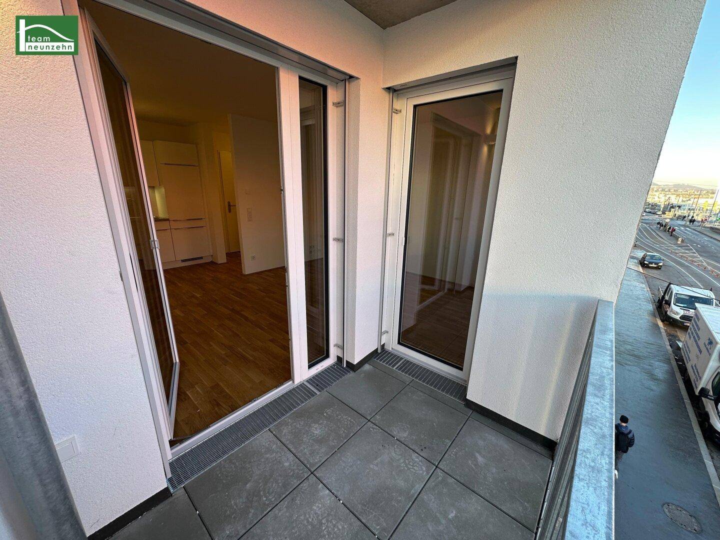 Kleiner Balkon mit Fliesenboden und Blick auf die Straße.