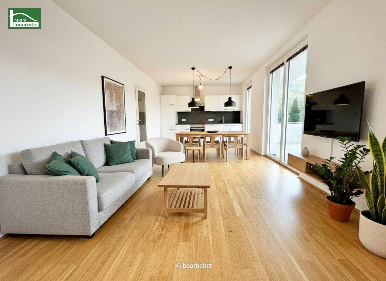 Heller offener Wohn-Essbereich mit Holzboden, moderner Einrichtung und Zugang zum Balkon.