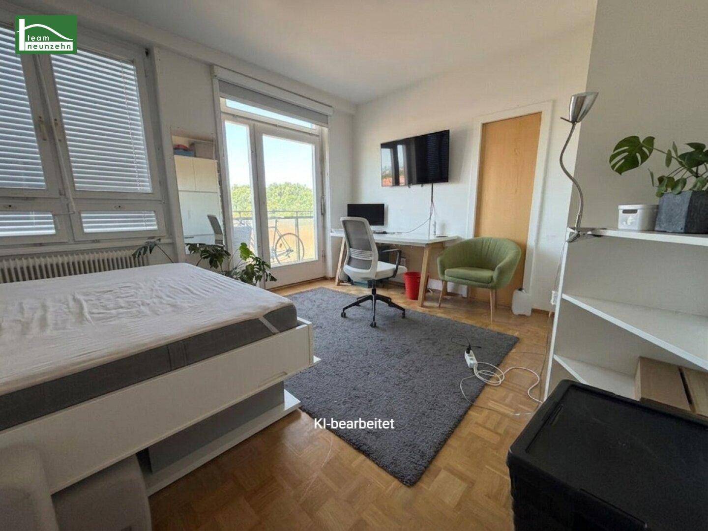 Heller Raum mit Parkettboden, Wandbett und Arbeitsbereich am Fenster.