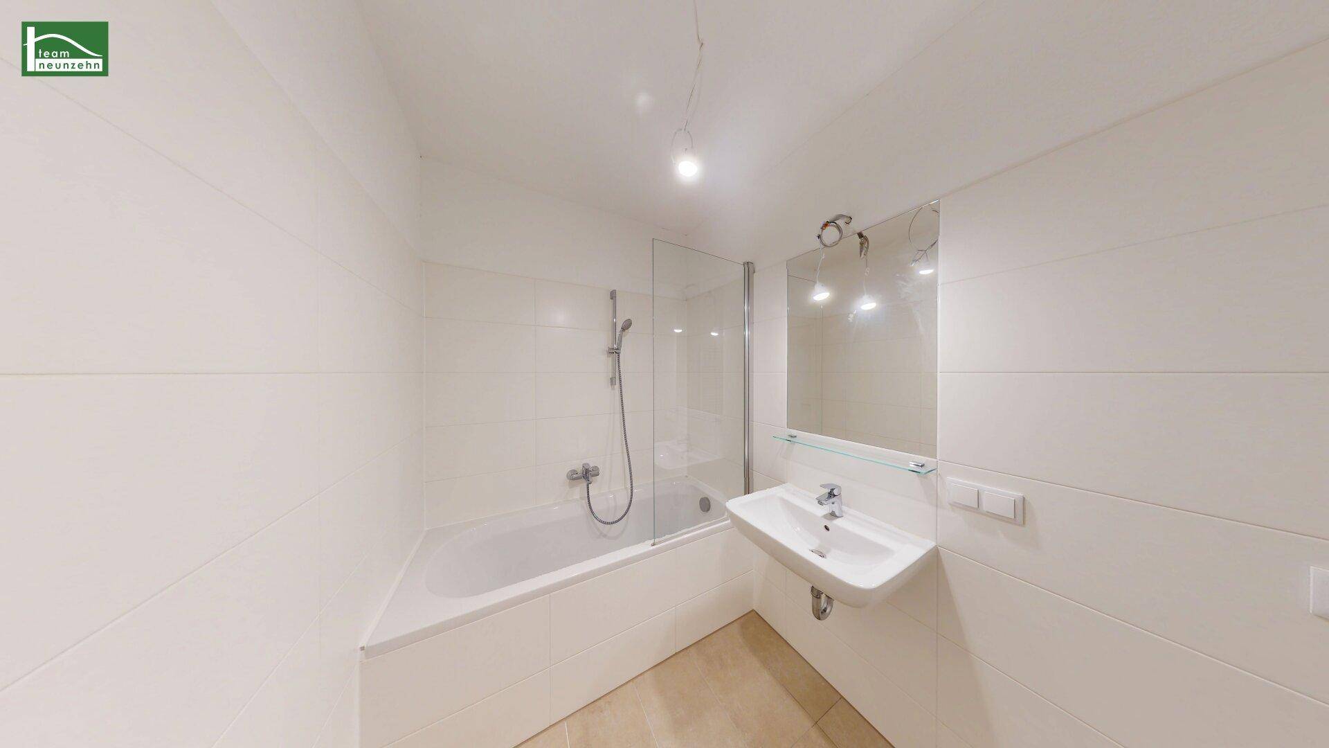 Modernes Badezimmer mit Badewanne, Duschabtrennung und Waschbecken.