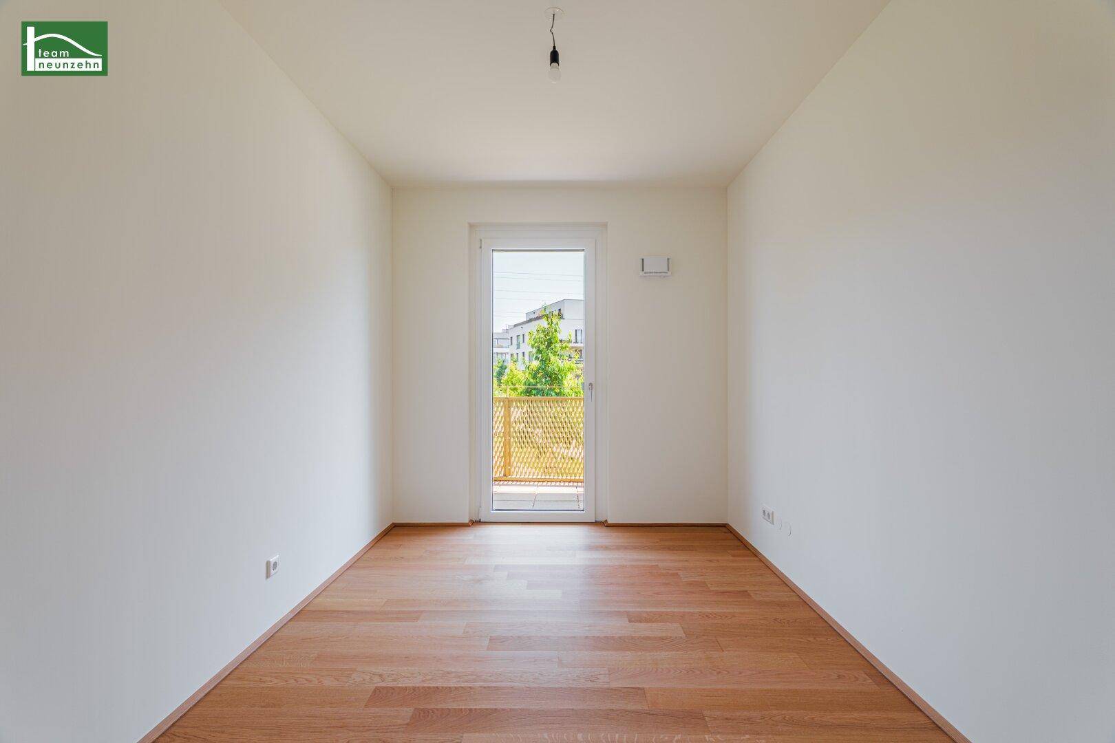 Heller, leerer Raum mit Holzboden und Zugang zu einem Außenbereich, ideal für individuelle Gestaltung.