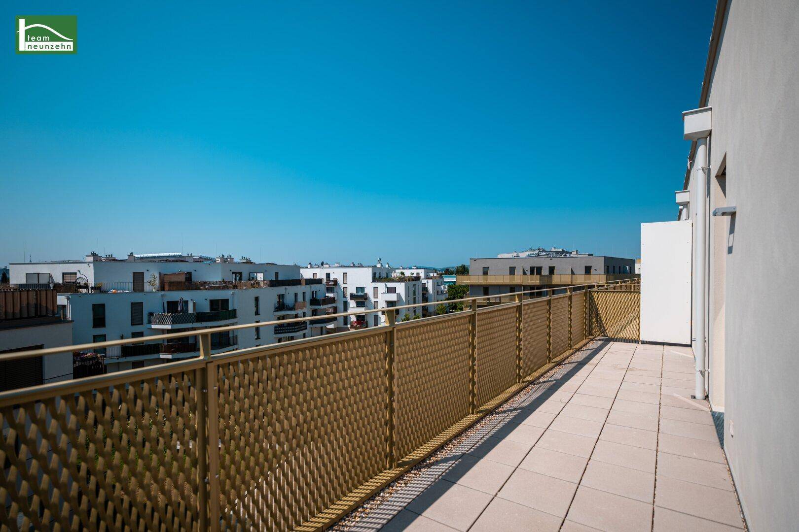 Großer Balkon mit modernen Metallgeländern und Blick auf die umliegenden Wohngebäude.