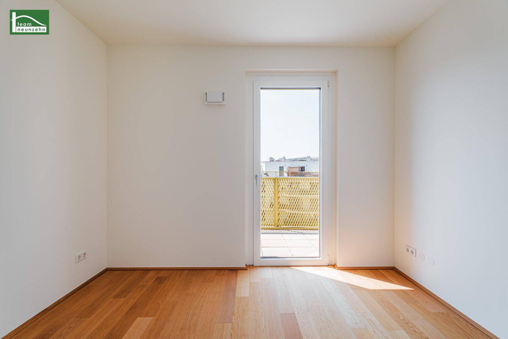 Helles Zimmer mit Holzboden und Balkonzugang, ideal als Schlaf- oder Arbeitszimmer in der neuen Wohnung.