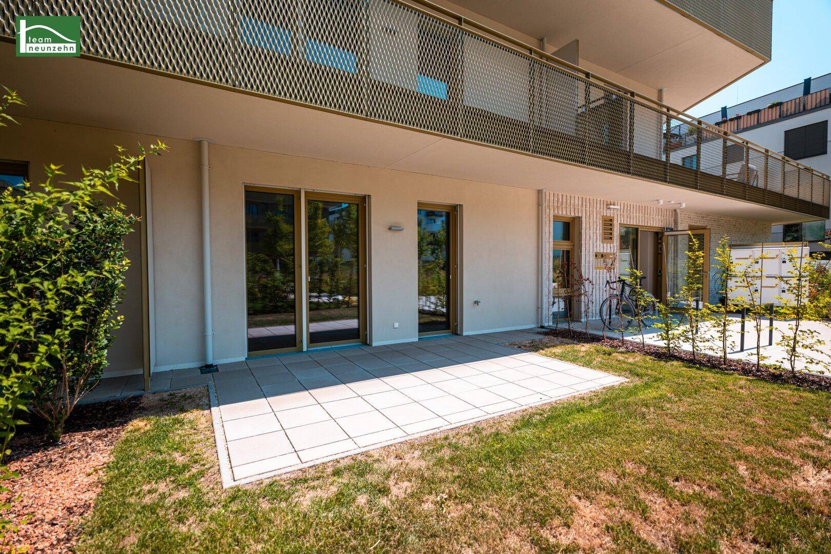 Großzügige Terrasse im Erdgeschoss mit Blick auf die moderne Wohnanlage und den Gartenbereich.