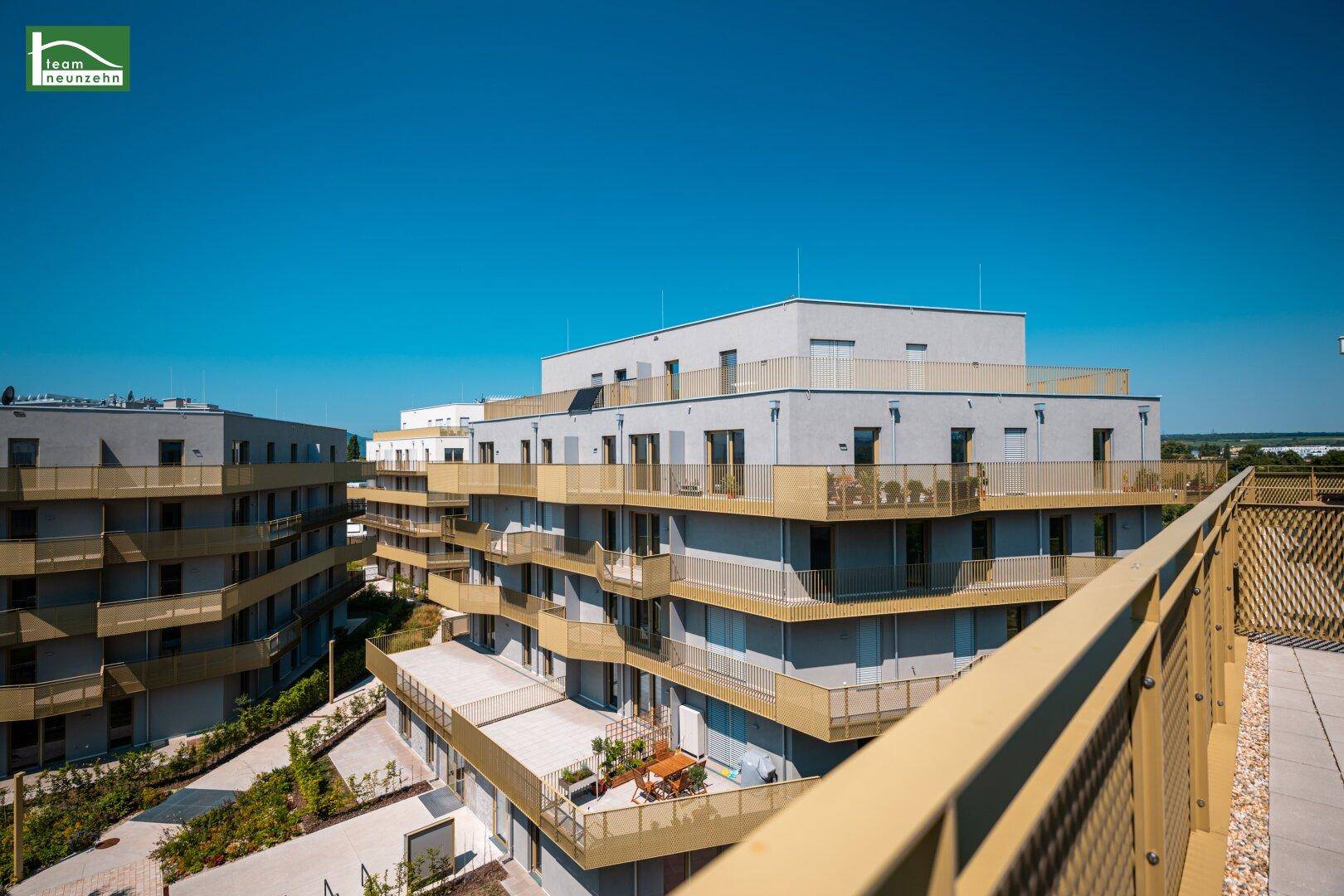 Großer Balkon mit Blick auf die moderne Architektur der umliegenden Wohngebäude.