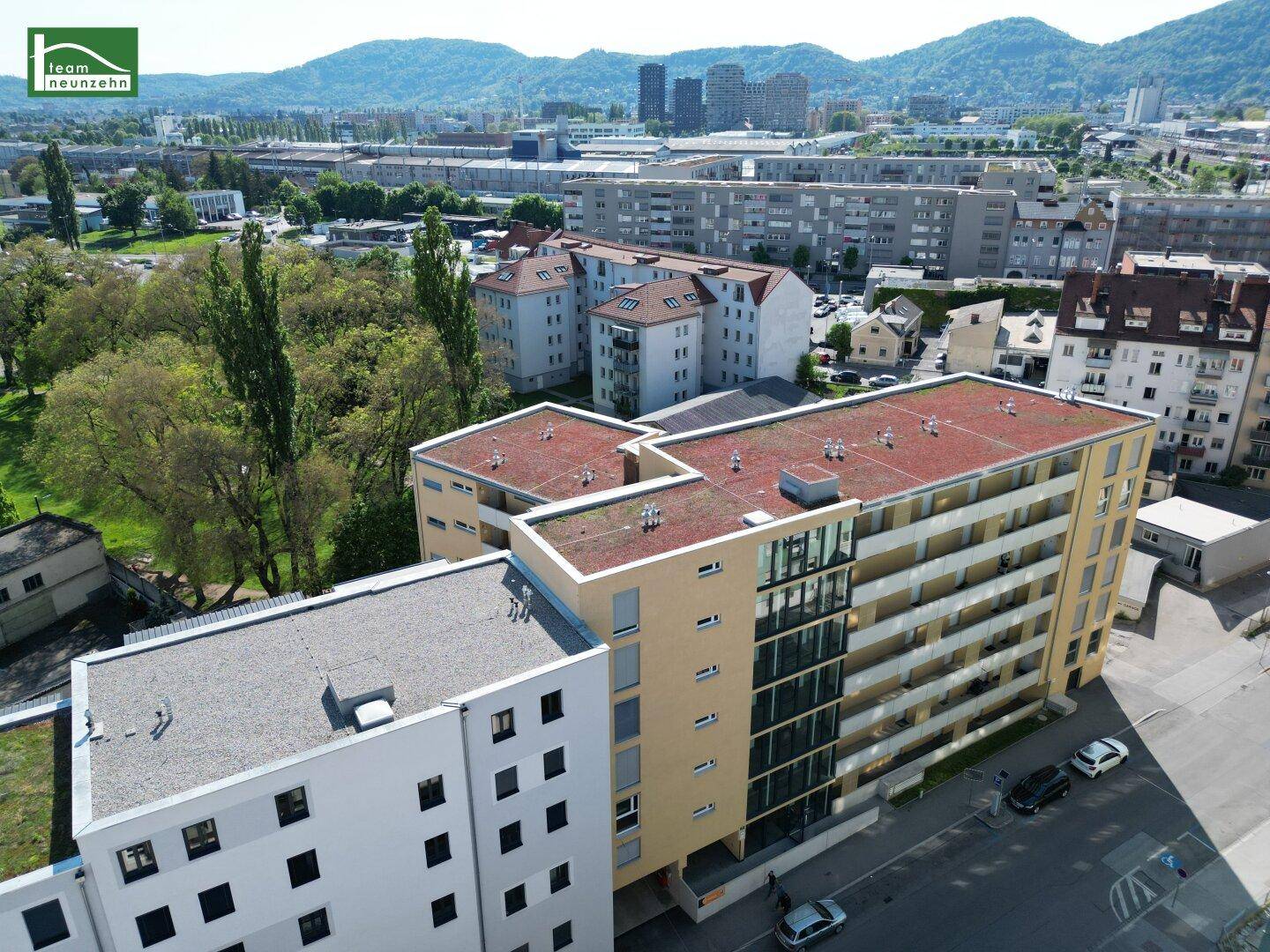 Moderne Wohngebäude mit Flachdächern und Balkonen in einer städtischen Umgebung.