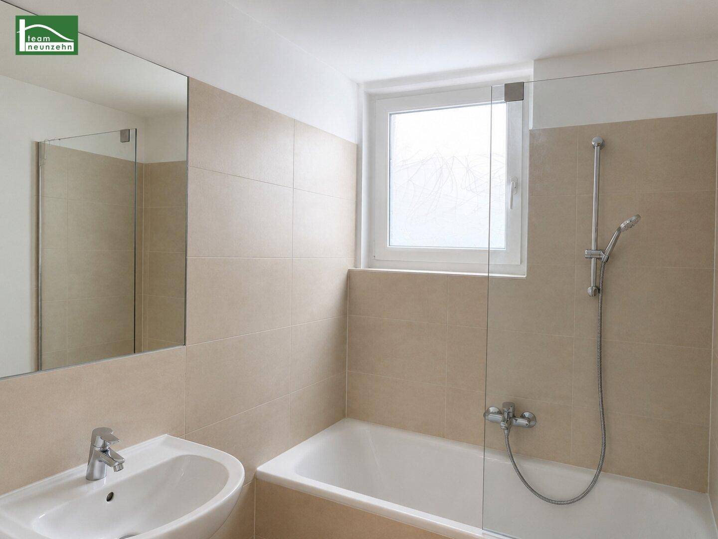 Modernes Badezimmer mit beigefarbenen Fliesen, Badewanne mit Duschfunktion und Fenster für Tageslicht.