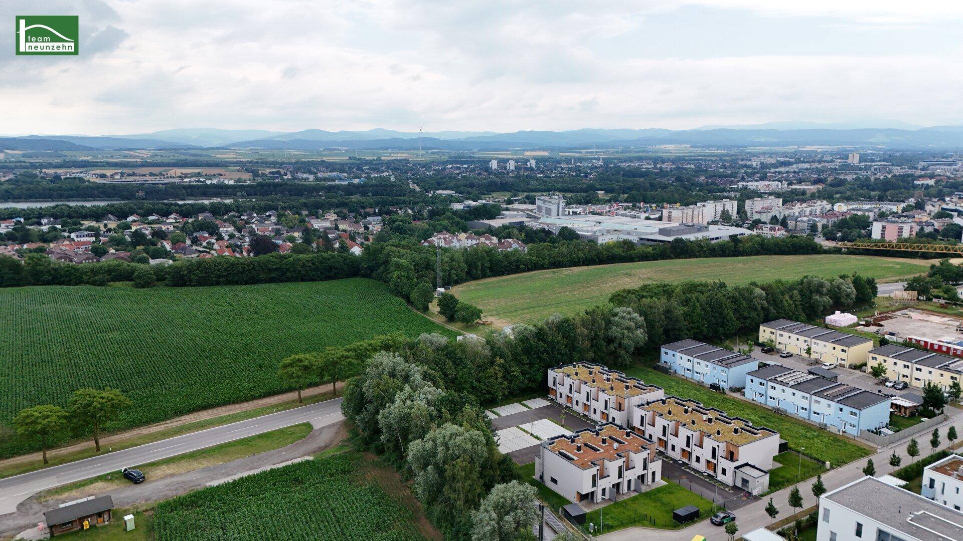 Luftbild der Wohnanlage mit weiten Feldern, Wäldern und einem Fluss in der Ferne.