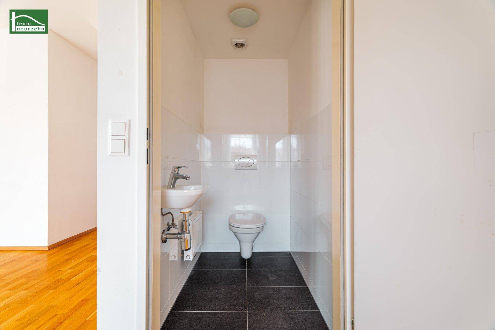 Kleines Gäste-WC mit wandhängender Toilette und Handwaschbecken, praktisch und platzsparend.