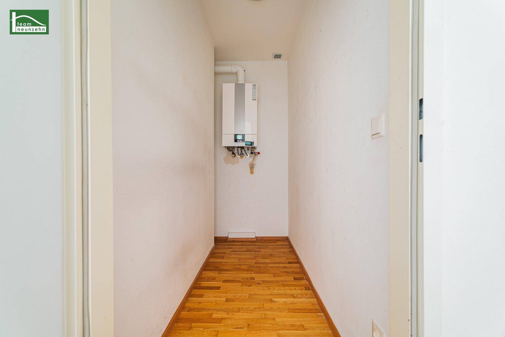 Praktischer Hauswirtschaftsraum mit Heizungsanlage und Holzparkettboden, ideal für Technik.
