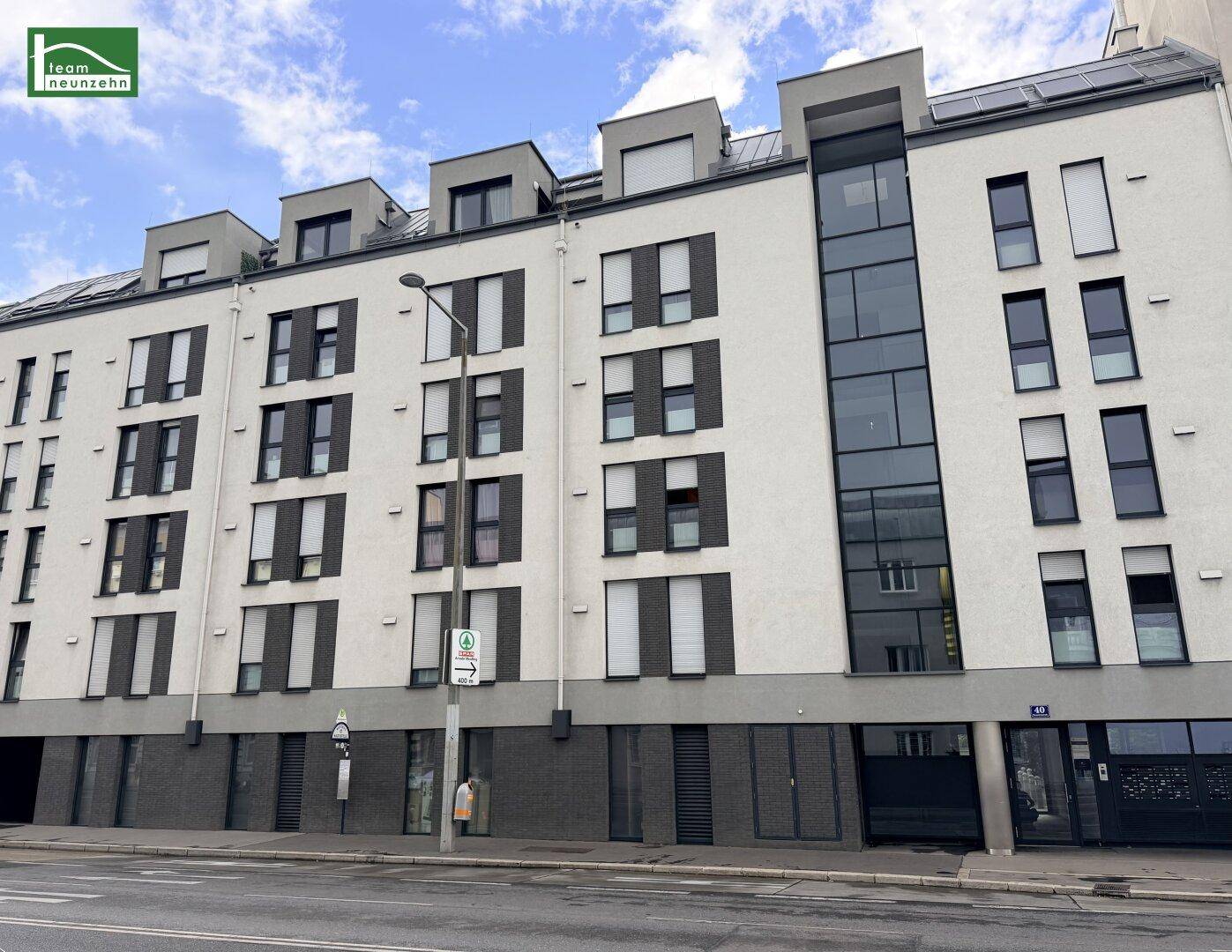 Ansicht der modernen Wohngebäude-Fassade mit markanter Glasfront und vielen Fenstern.