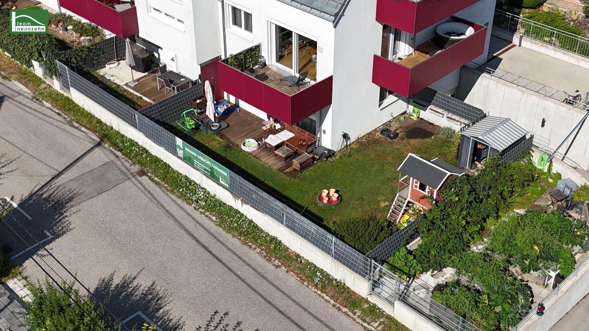 Gepflegter Gartenbereich mit Spielhaus, Sitzgelegenheiten und einem Whirlpool auf dem oberen Balkon.