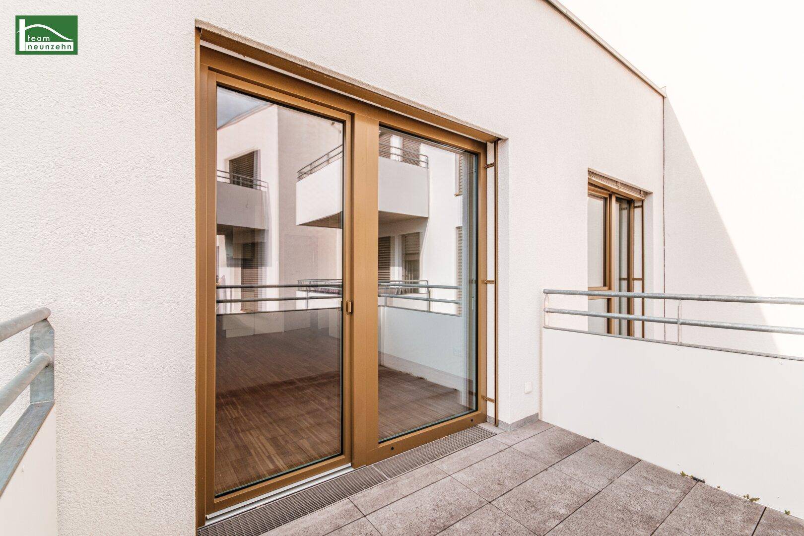 Heller Balkon mit Fliesenboden und Blick auf die umliegenden Gebäude.