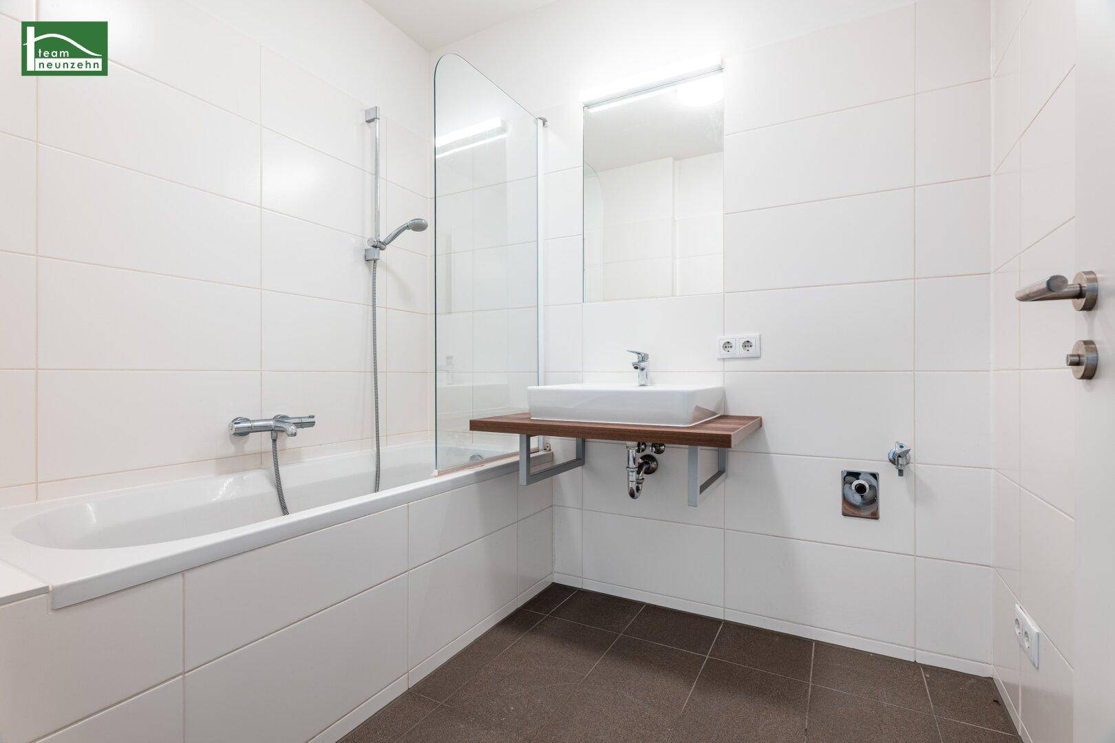 Modernes Badezimmer mit Badewanne, Duschabtrennung und Einzelwaschbecken.
