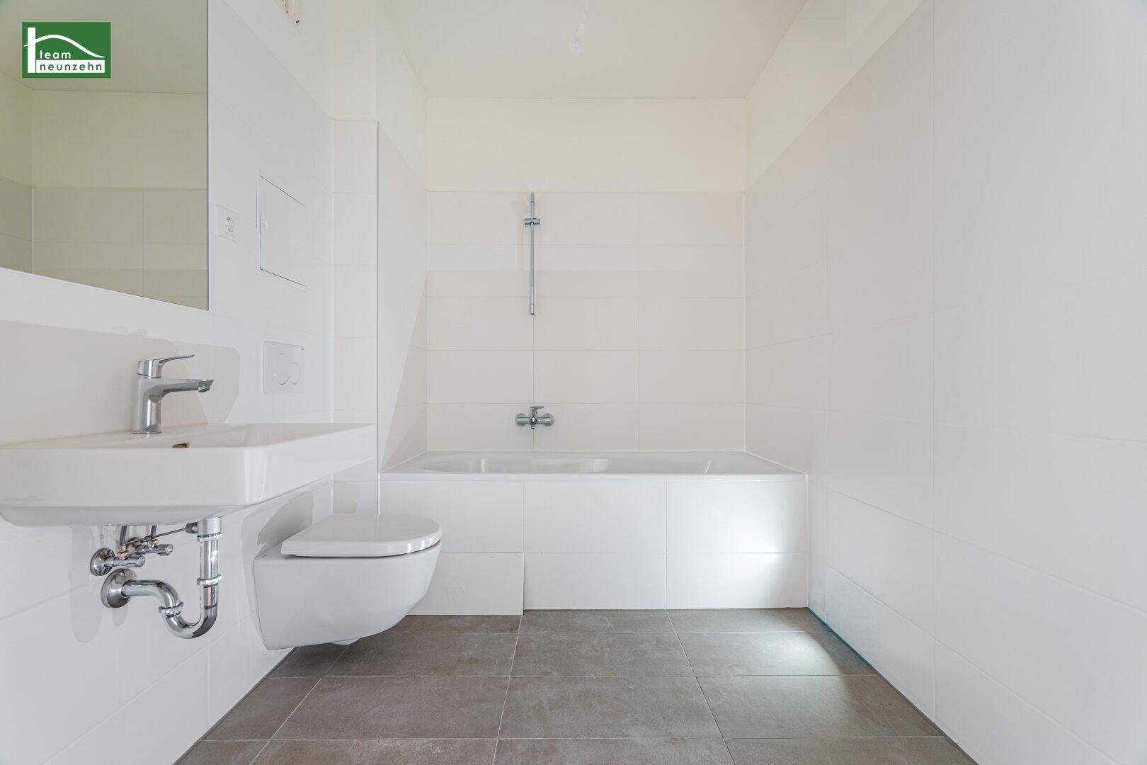 Helles Badezimmer mit Badewanne, wandhängendem WC und modernem Waschbecken.
