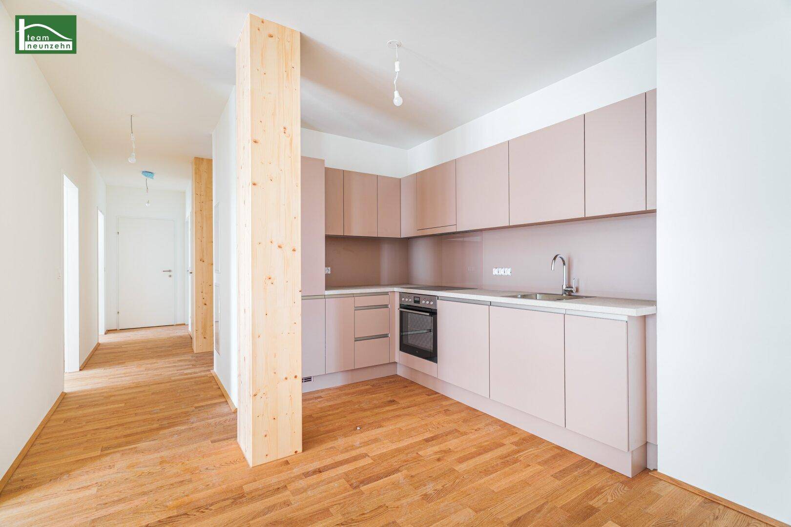 Moderne Einbauküche in hellem Roséton mit integriertem Backofen und Spülbecken.