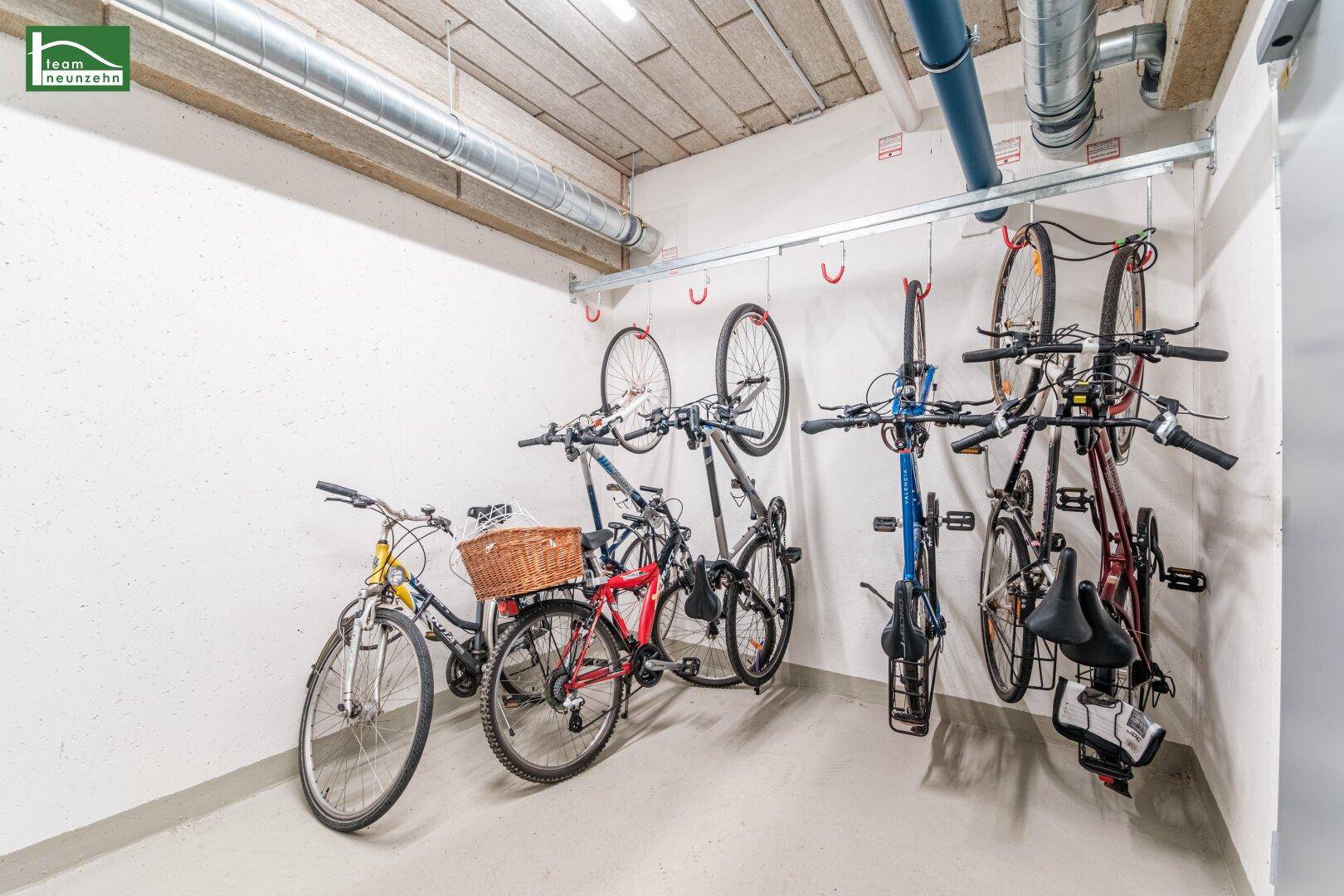 Fahrradraum mit praktischen Wandhalterungen für mehrere Fahrräder im Kellerbereich.