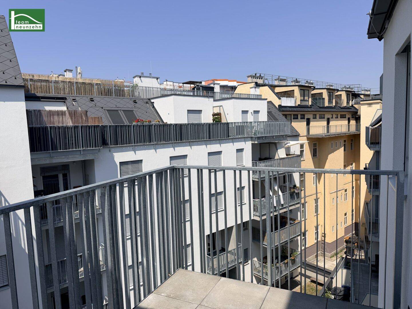 Blick von einem Balkon auf die umliegenden Gebäude und Dächer der Stadt.