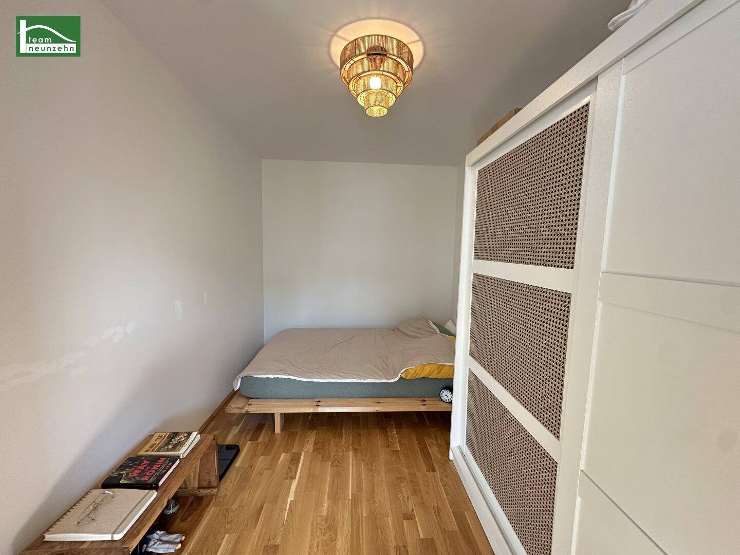 Gemütliches Schlafzimmer mit Holzboden, Bett und einem großen Kleiderschrank.