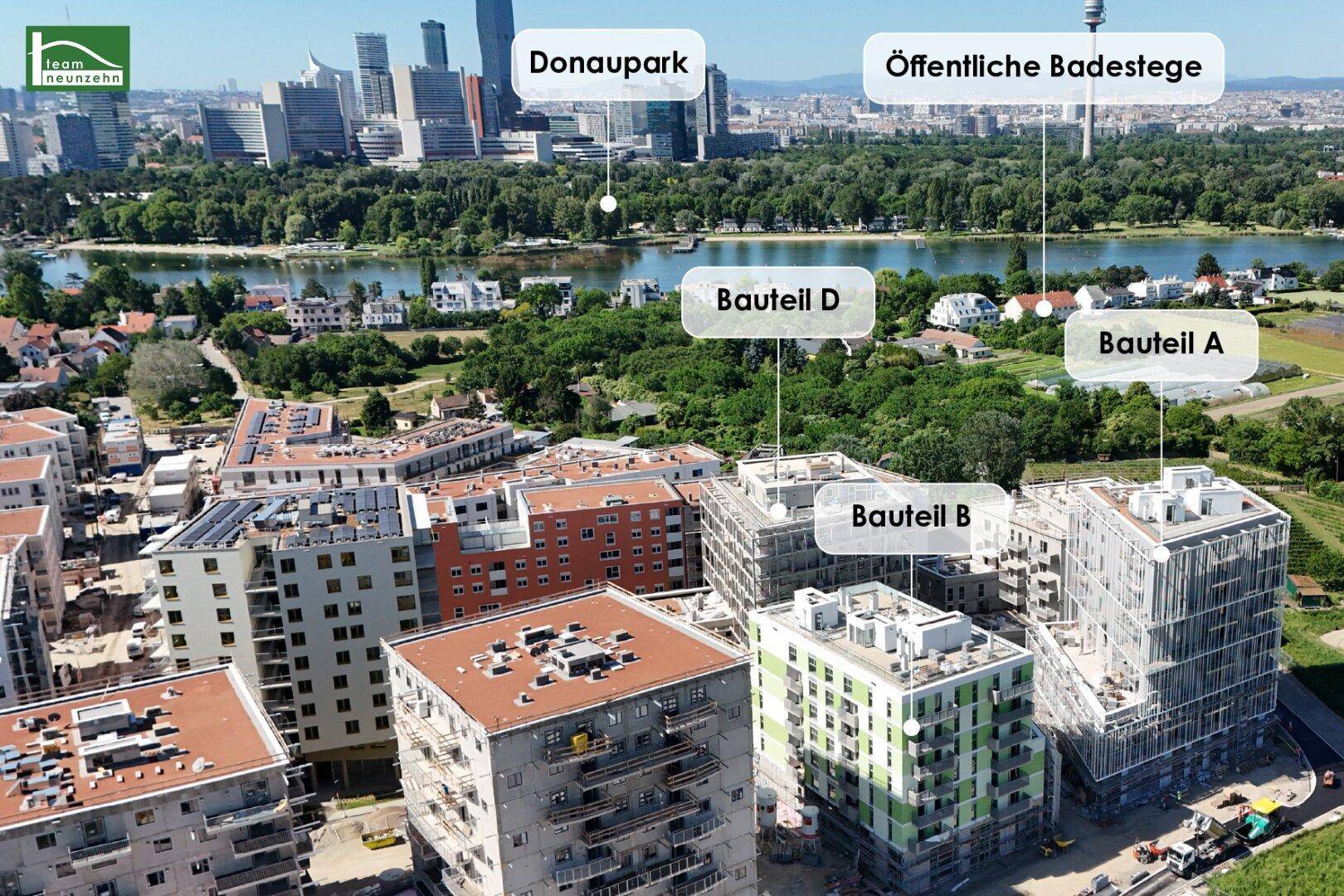 Luftaufnahme des Neubauprojekts mit verschiedenen Bauteilen und Blick auf den Donaupark und die Badestege.