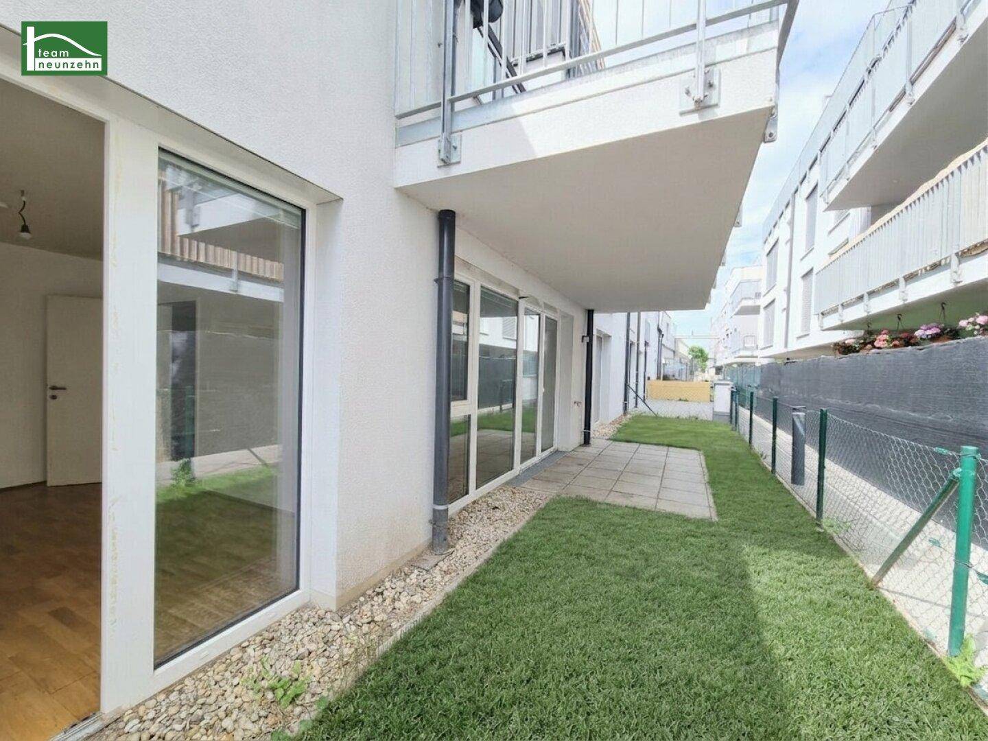 Kleiner privater Gartenbereich mit Rasenfläche und gepflasterter Terrasse neben dem Gebäude.