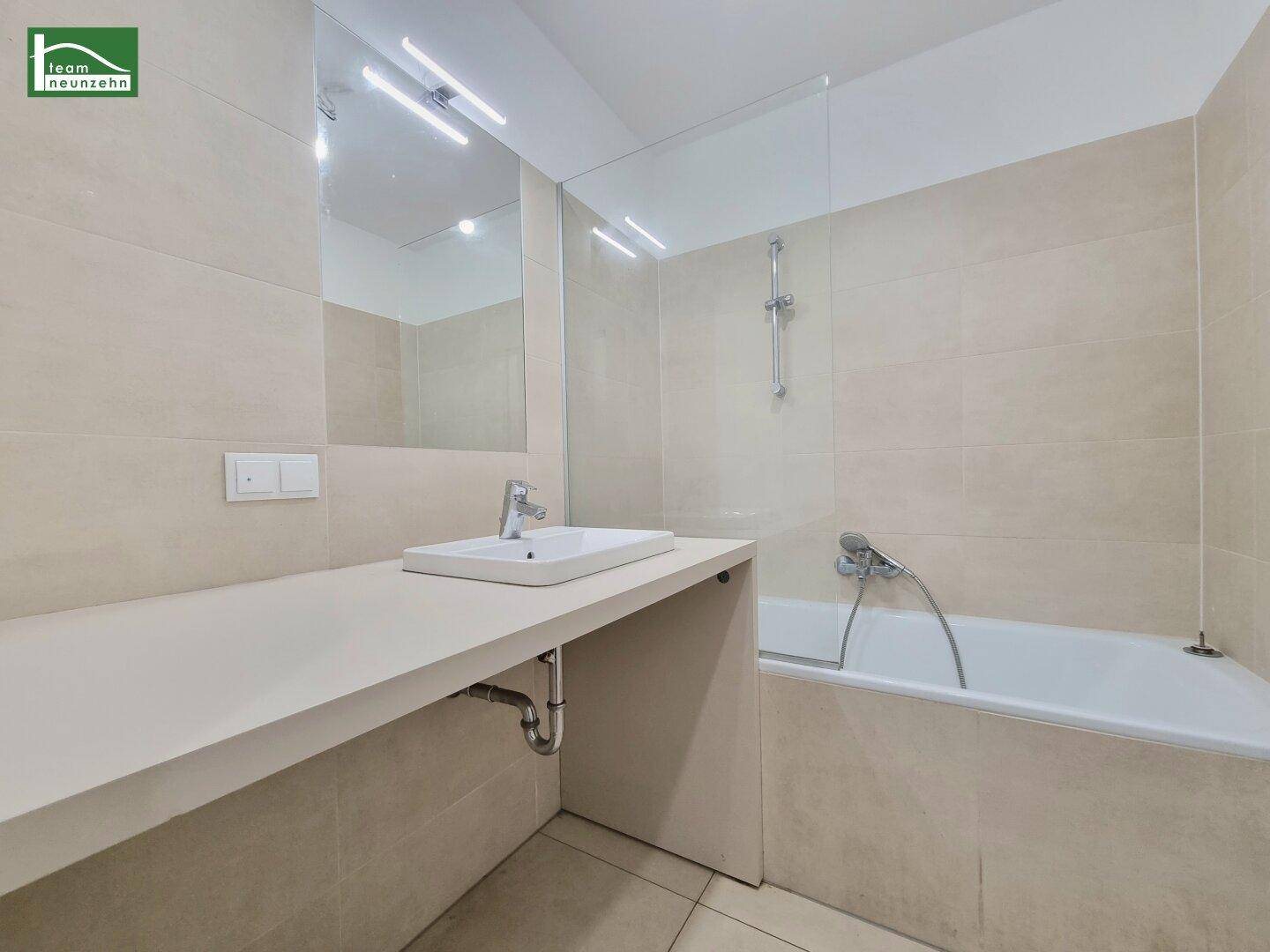 Modernes Badezimmer mit Badewanne, Dusche und großem Waschbecken.