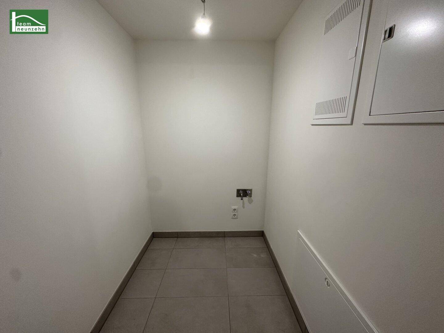 Praktischer Abstellraum mit Fliesenboden und Anschlüssen für Haushaltsgeräte, bietet zusätzlichen Stauraum.