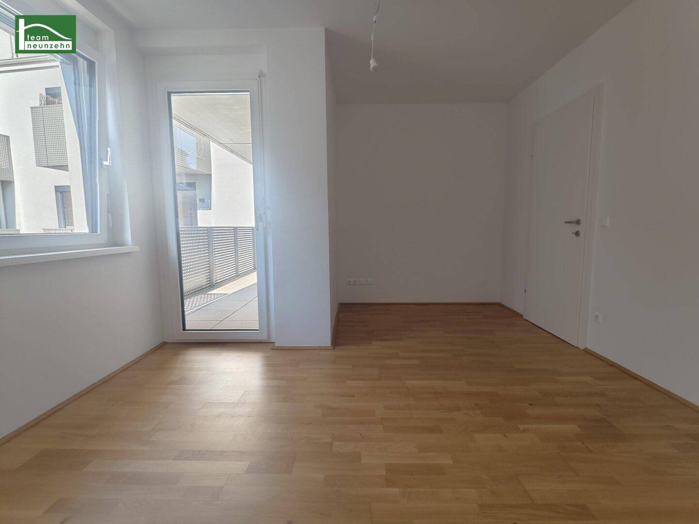 Helles Zimmer mit Holzboden und direktem Zugang zu einem Außenbereich, ideal als Schlaf- oder Arbeitszimmer.