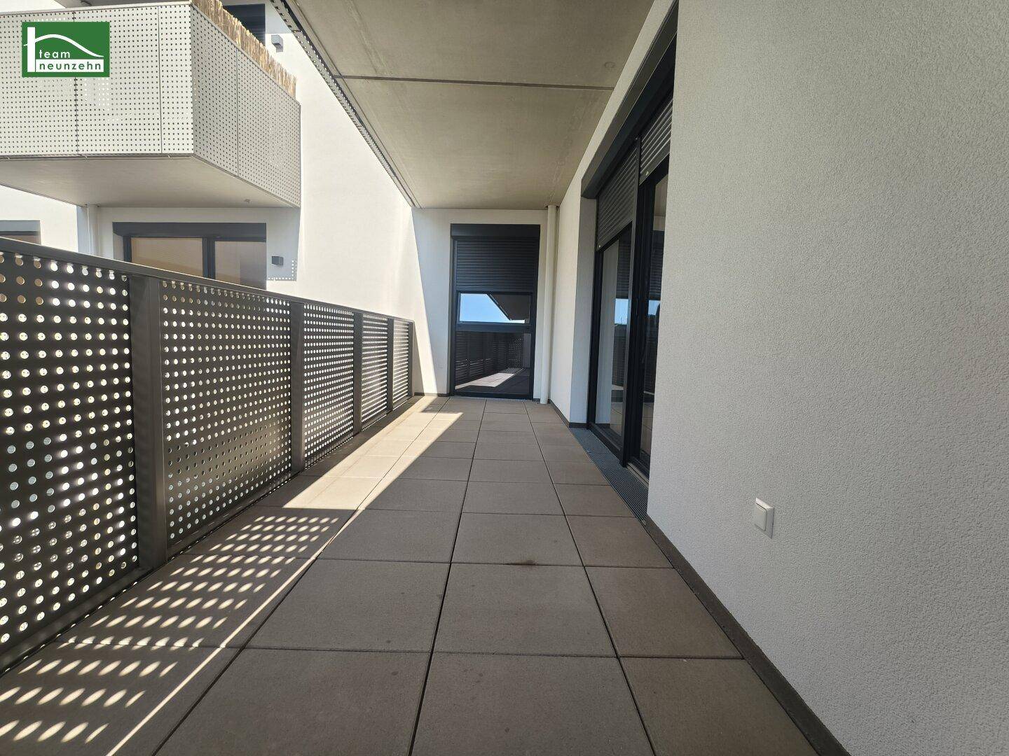 Geräumiger Balkon mit Fliesenboden und moderner Metallbrüstung, bietet Platz für Entspannung im Freien.