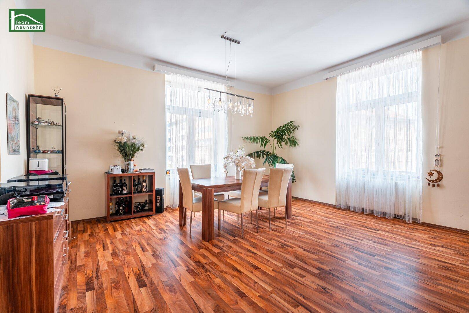 Eleganter Essbereich mit Holztisch, passenden Stühlen und großen Fenstern für viel Licht.