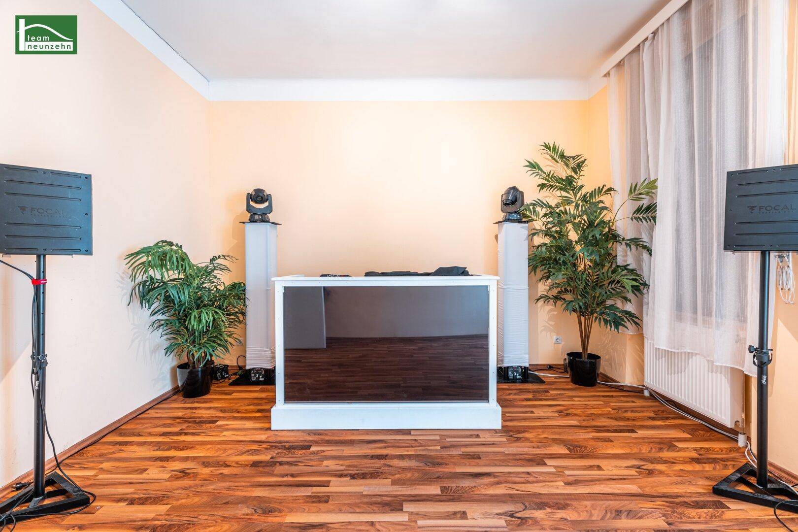 Raum mit Laminatboden, DJ-Pult und professioneller Soundanlage.
