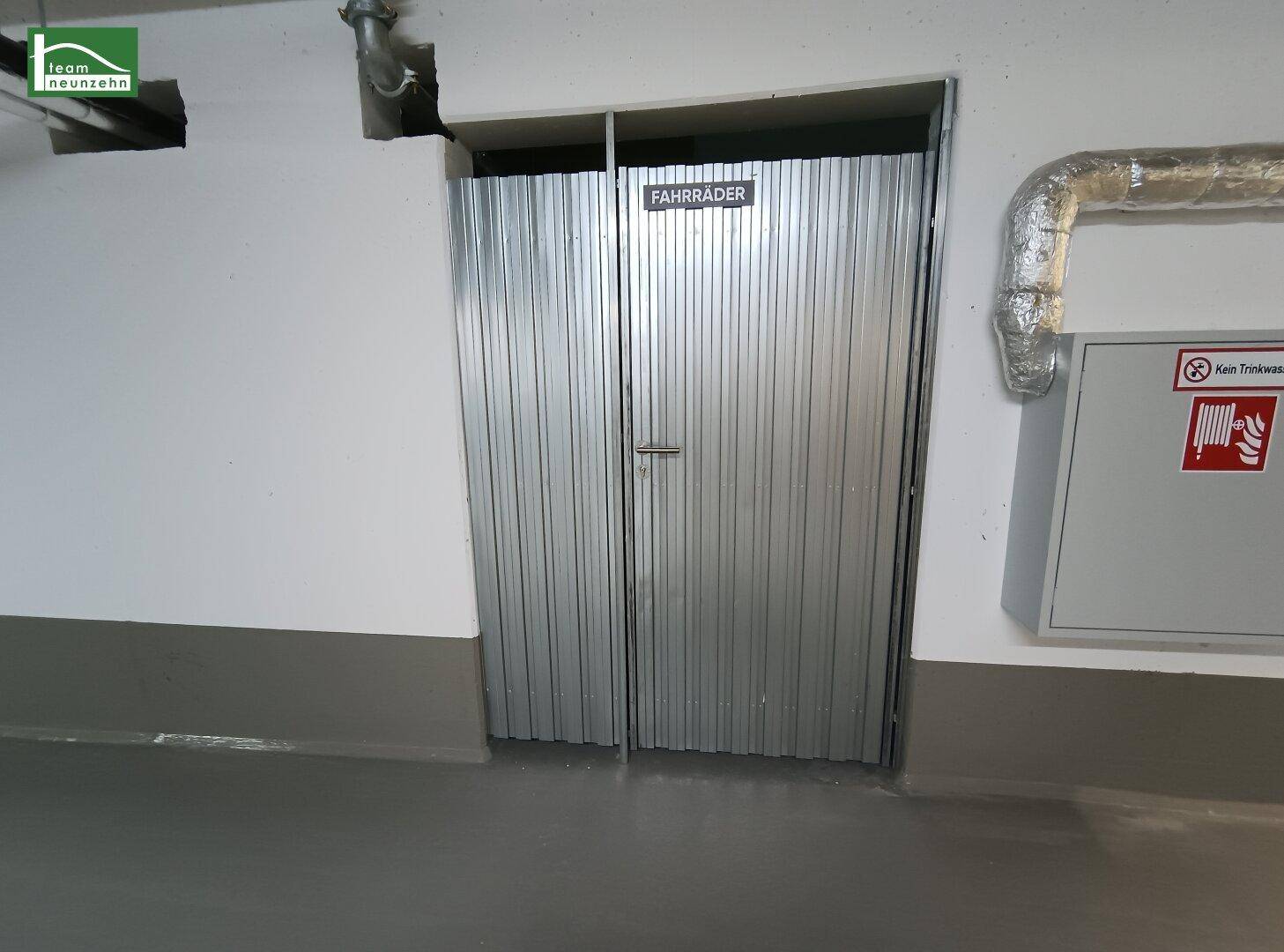Fahrradraum mit Metalltüren im Untergeschoss, bietet sicheren Stauraum für Fahrräder.