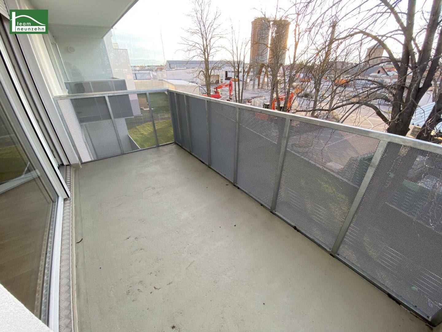 Geräumiger Balkon mit Metallgeländer und Blick auf die Umgebung, ideal für frische Luft.