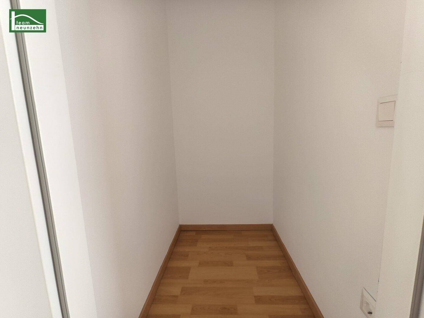 Kleiner, leerer Abstellraum mit Holzboden und weißen Wänden, ideal für zusätzlichen Stauraum.