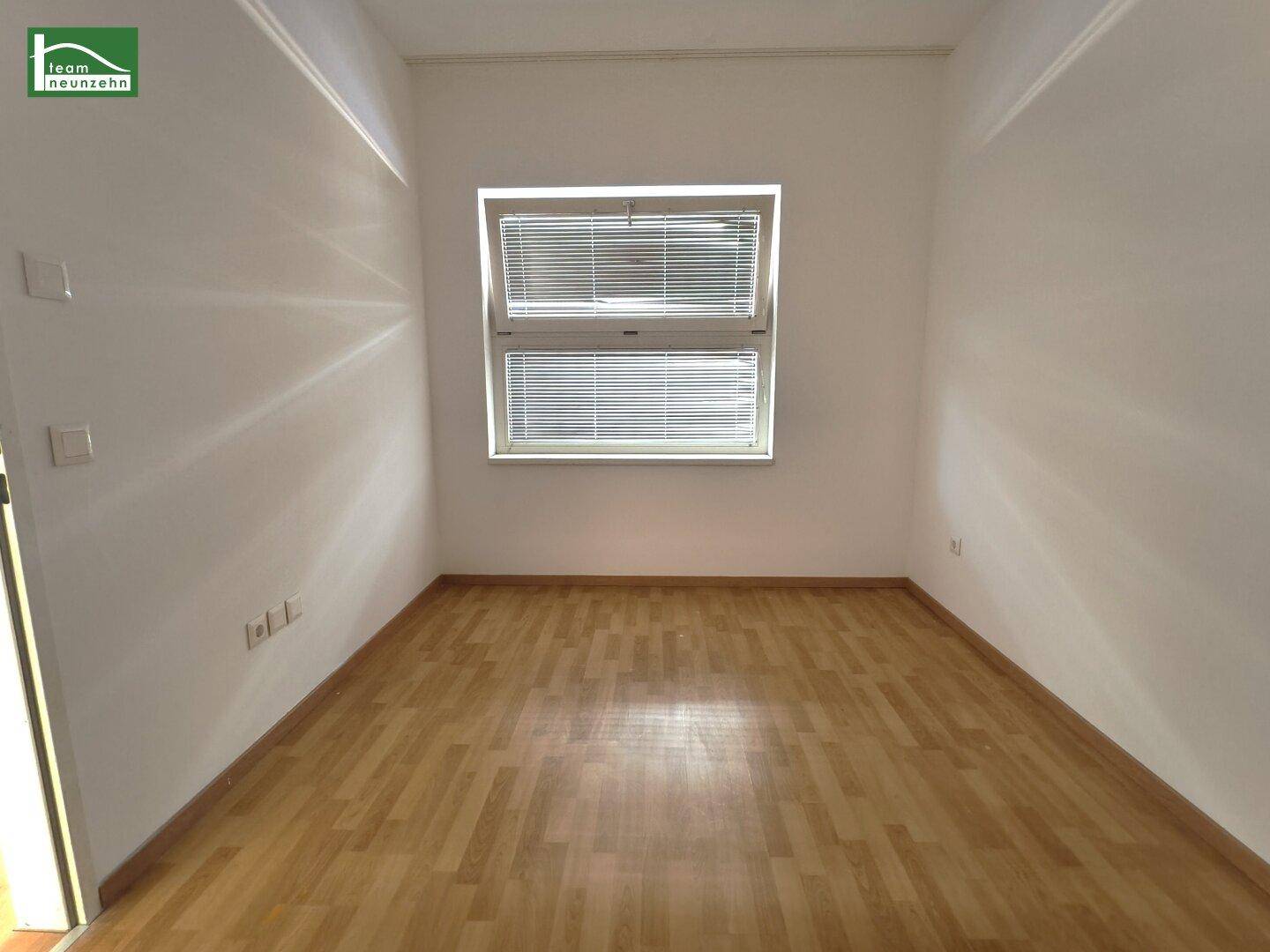 Ruhiges Zimmer mit Holzboden und einem Fenster mit Jalousien, ideal als Schlaf- oder Arbeitszimmer.