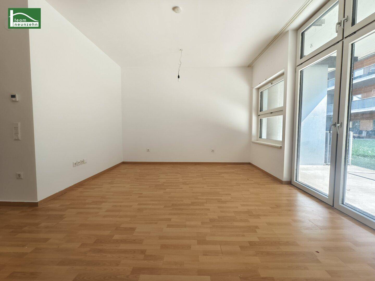 Geräumiges, leeres Zimmer mit hellen Wänden und Holzboden, bereit zur individuellen Gestaltung.