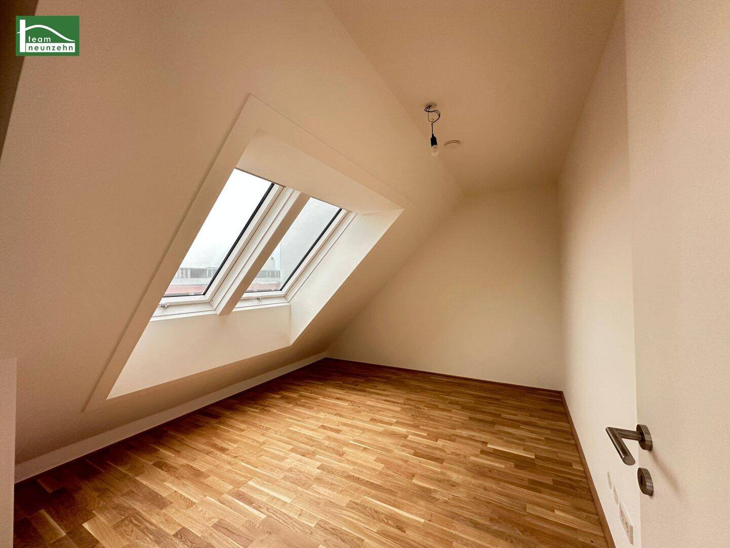 Helles Zimmer mit Dachschrägen und zwei großen Dachfenstern, ideal als Schlaf- oder Arbeitszimmer.