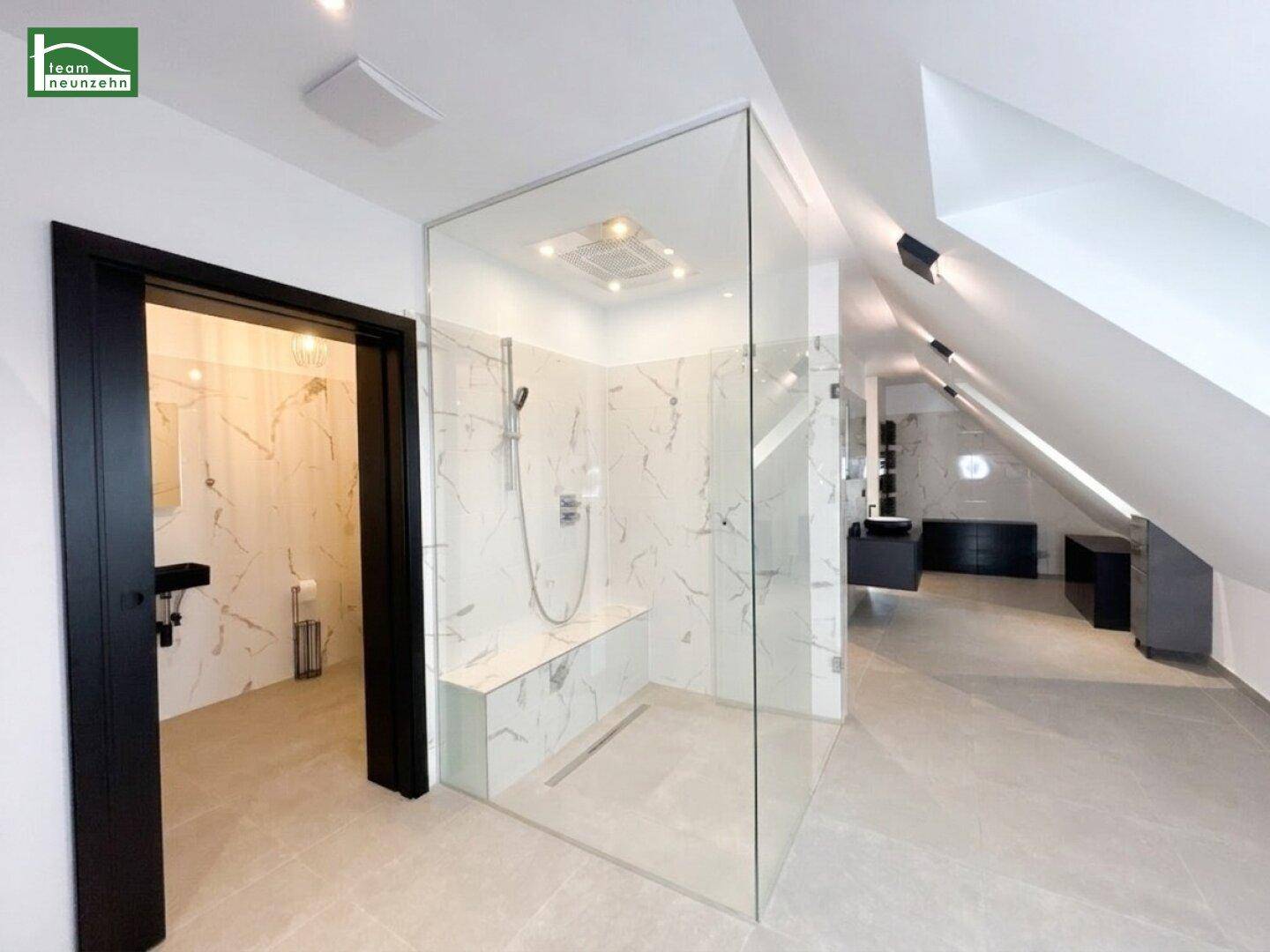Großes, luxuriöses Badezimmer mit begehbarer Dusche und Marmorfliesen.