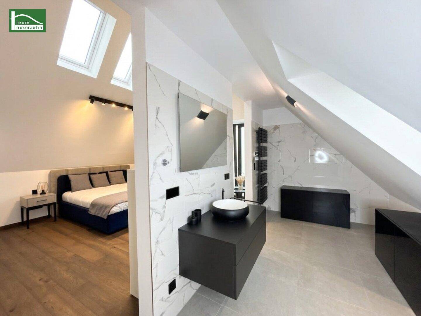 Offenes Badezimmer mit modernem Waschtisch und Blick auf das angrenzende Schlafzimmer.